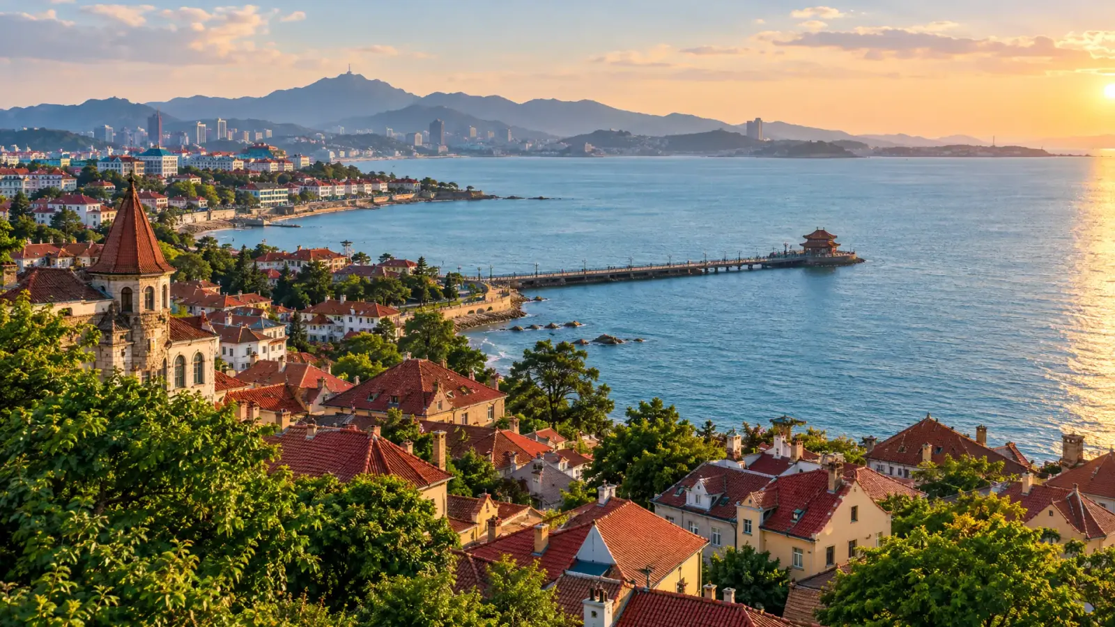 Pohled shora na červené střechy pobřežního starého města Qingdao a modrý záliv