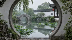 Kruhová měsíční brána rámující tichý rybník s lekníny a kamenný most v Suzhou