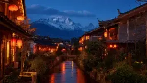 Staré město Lijiang v Yunnanu za modré hodiny s červenými lampiony a kanálem, v pozadí zasněžená hora